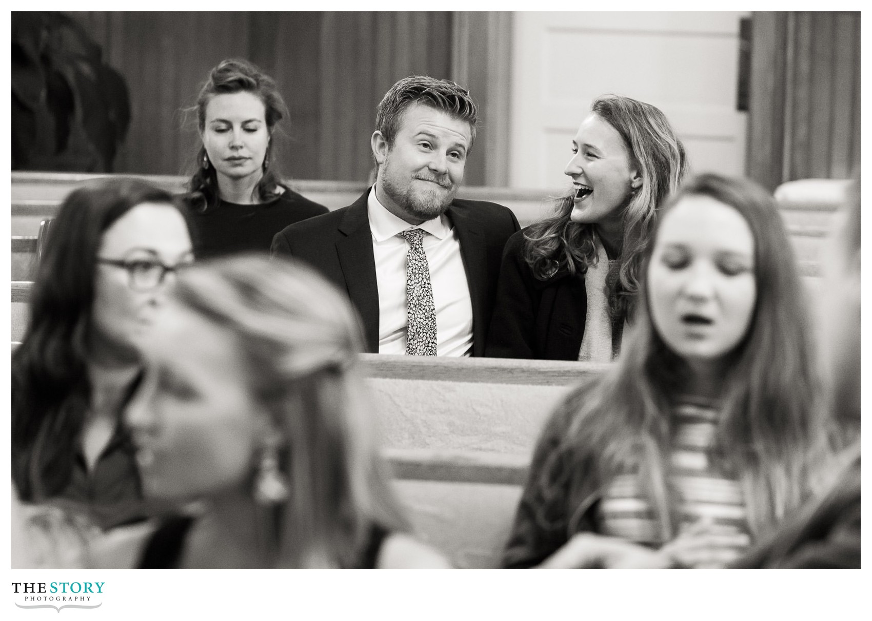 candid moment of wedding guests enjoying a fun moment during the ceremony