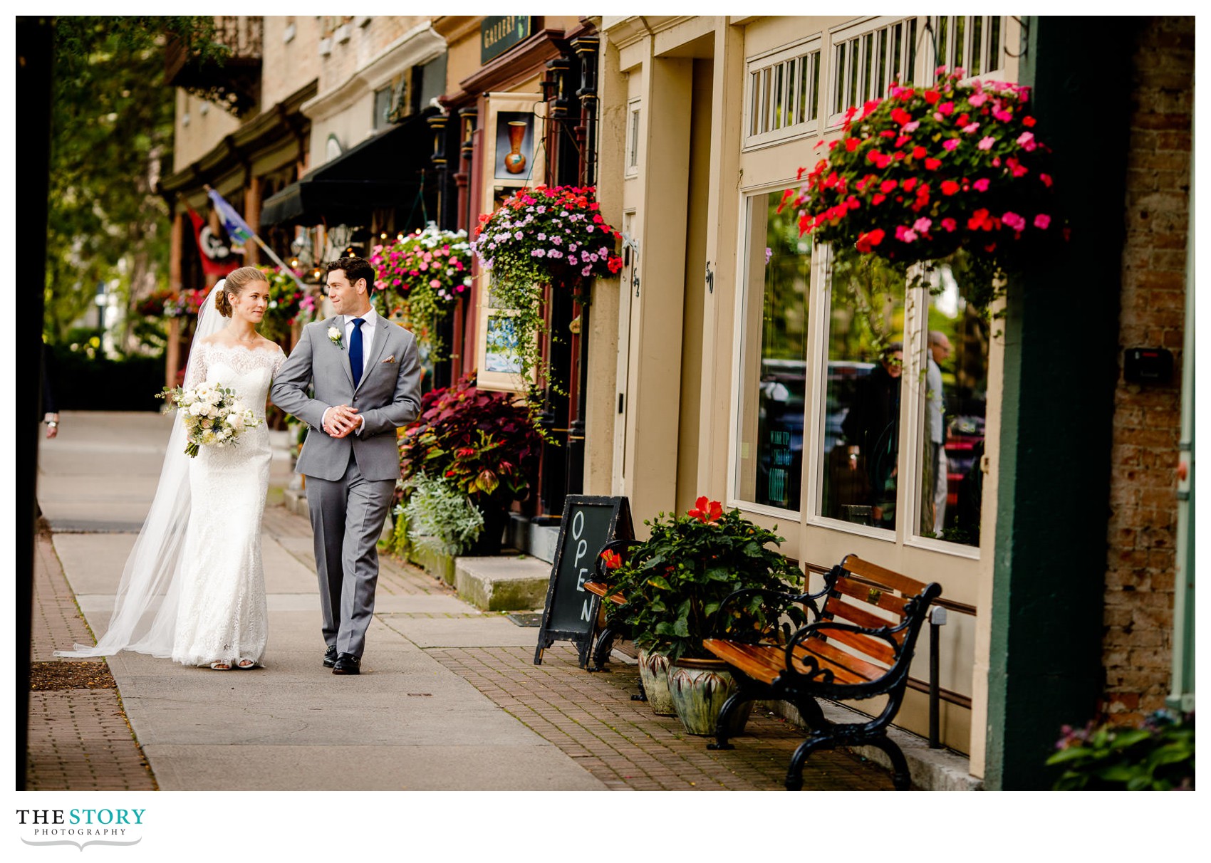 village of Skaneateles wedding photo of bride and groom walking down sidewalk