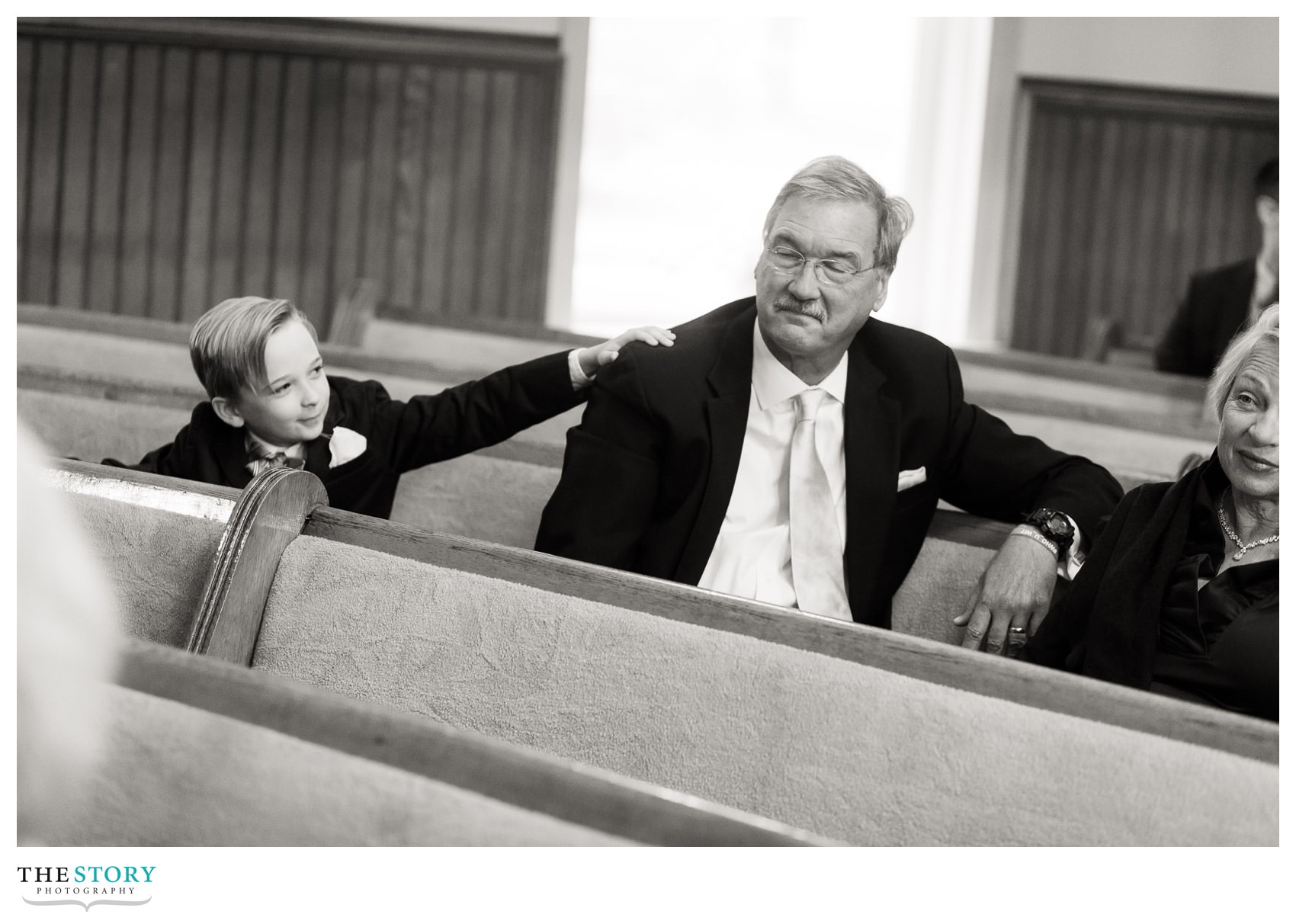 little boy puts his hand on the shoulder of his grandfather during wedding ceremony