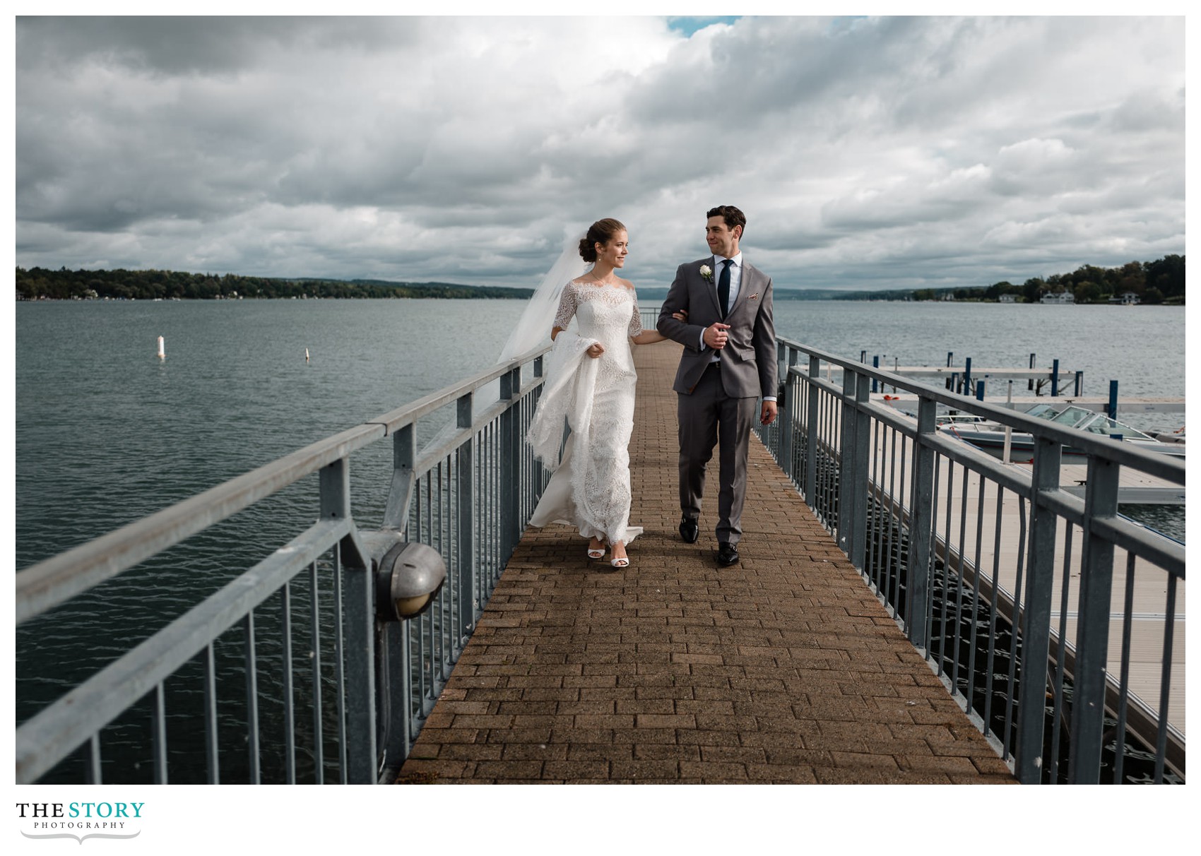 bride and groom walking Skaeateles Pier all alone