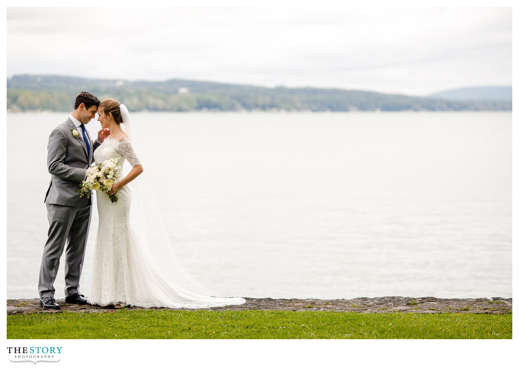 relaxed bride and groom wedding photo in front of Skaneateles Lake in Shotwell Park