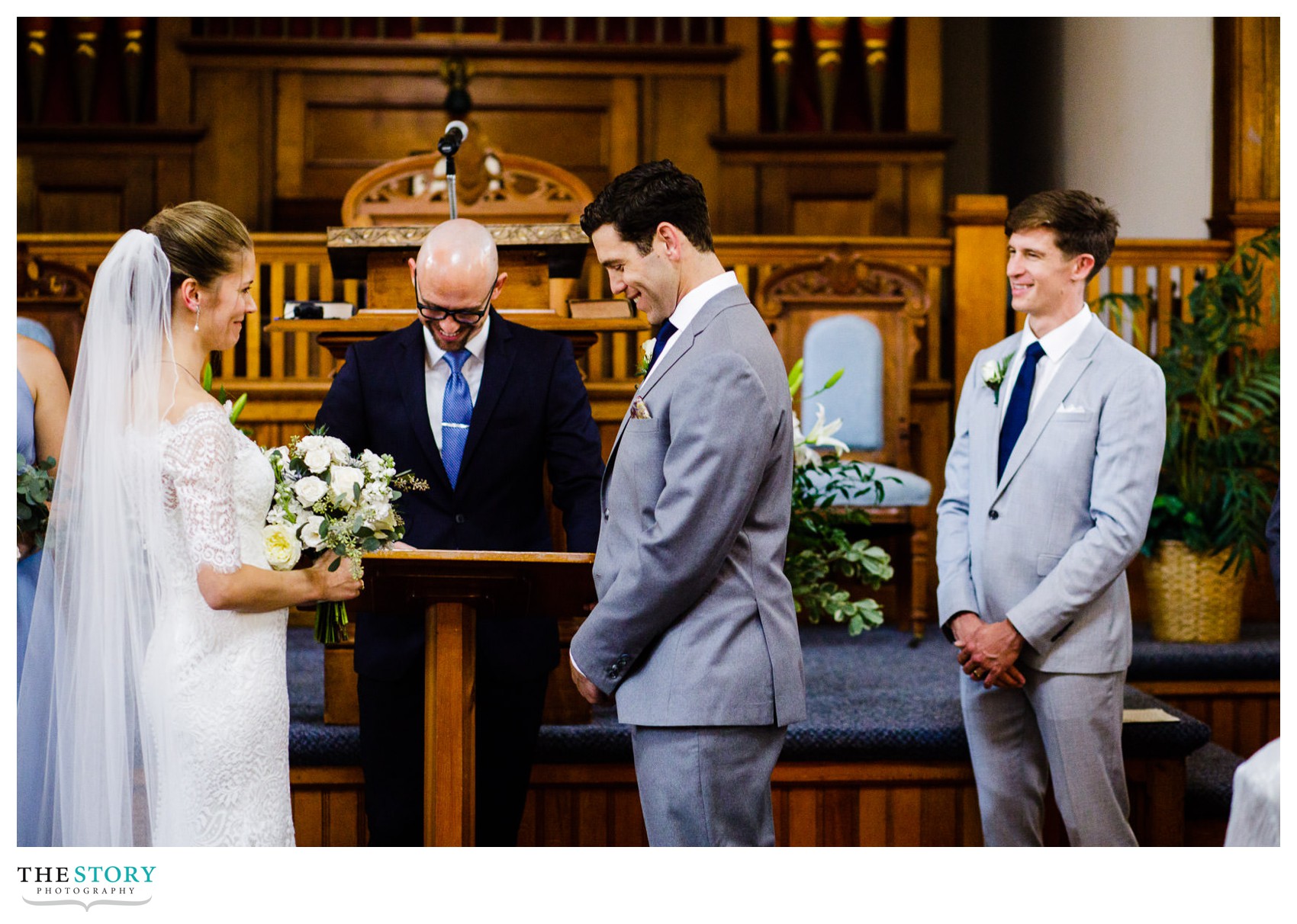 bride and groom can't help but smile as the wedding ceremony begins