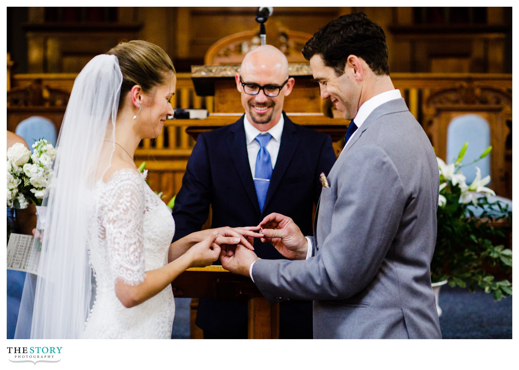 bride and groom exchange rings during the wedding ceremony at Skaneateles First Baptist Church