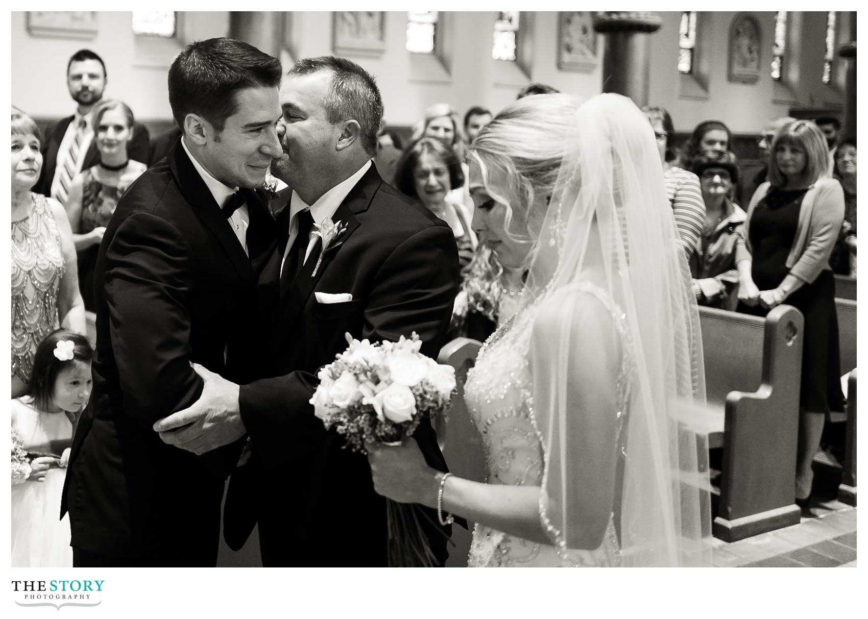 groom greets father of the bride at cathedral wedding