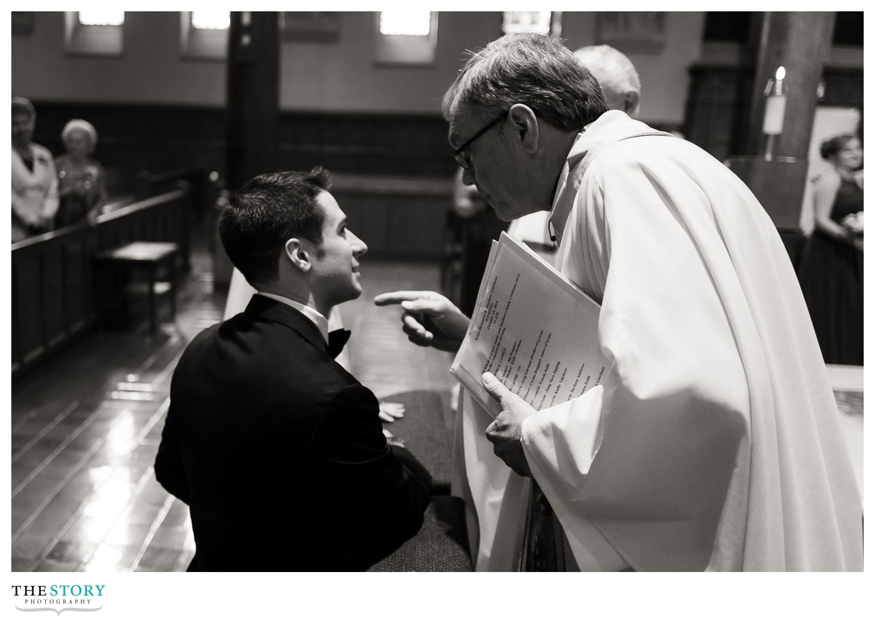 priest speaks to groom during wedding ceremony at syracuse cathedral