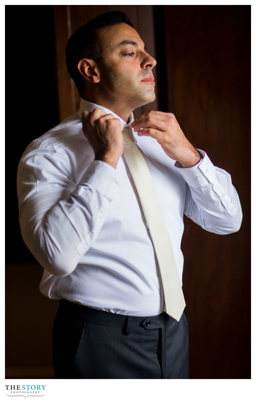 groom fixing his tie before Hotel Syracuse wedding