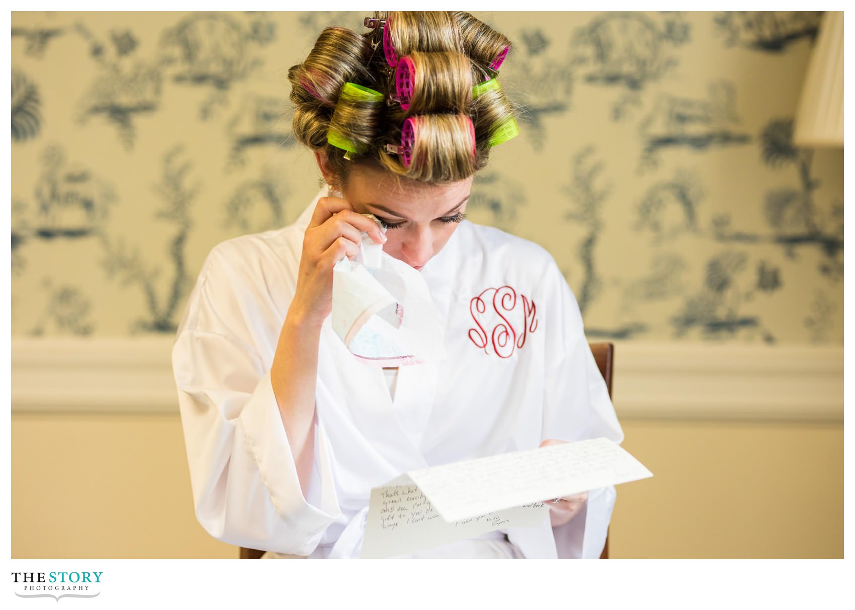 bride wipes a tear while reading letter from the groom at The Otesaga Resort