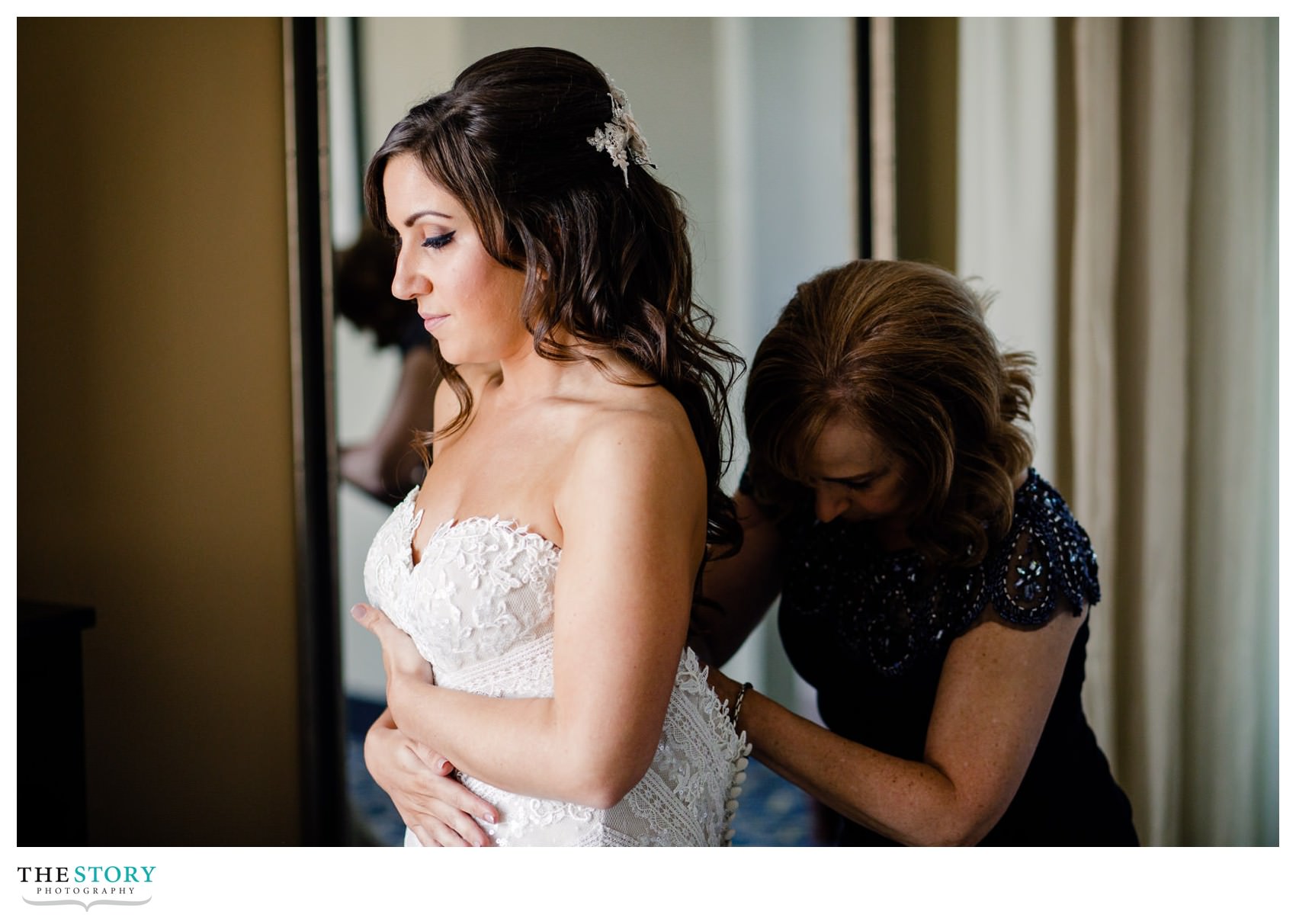 mother helps bride get wedding dress on at Jefferson Clinton Hotel
