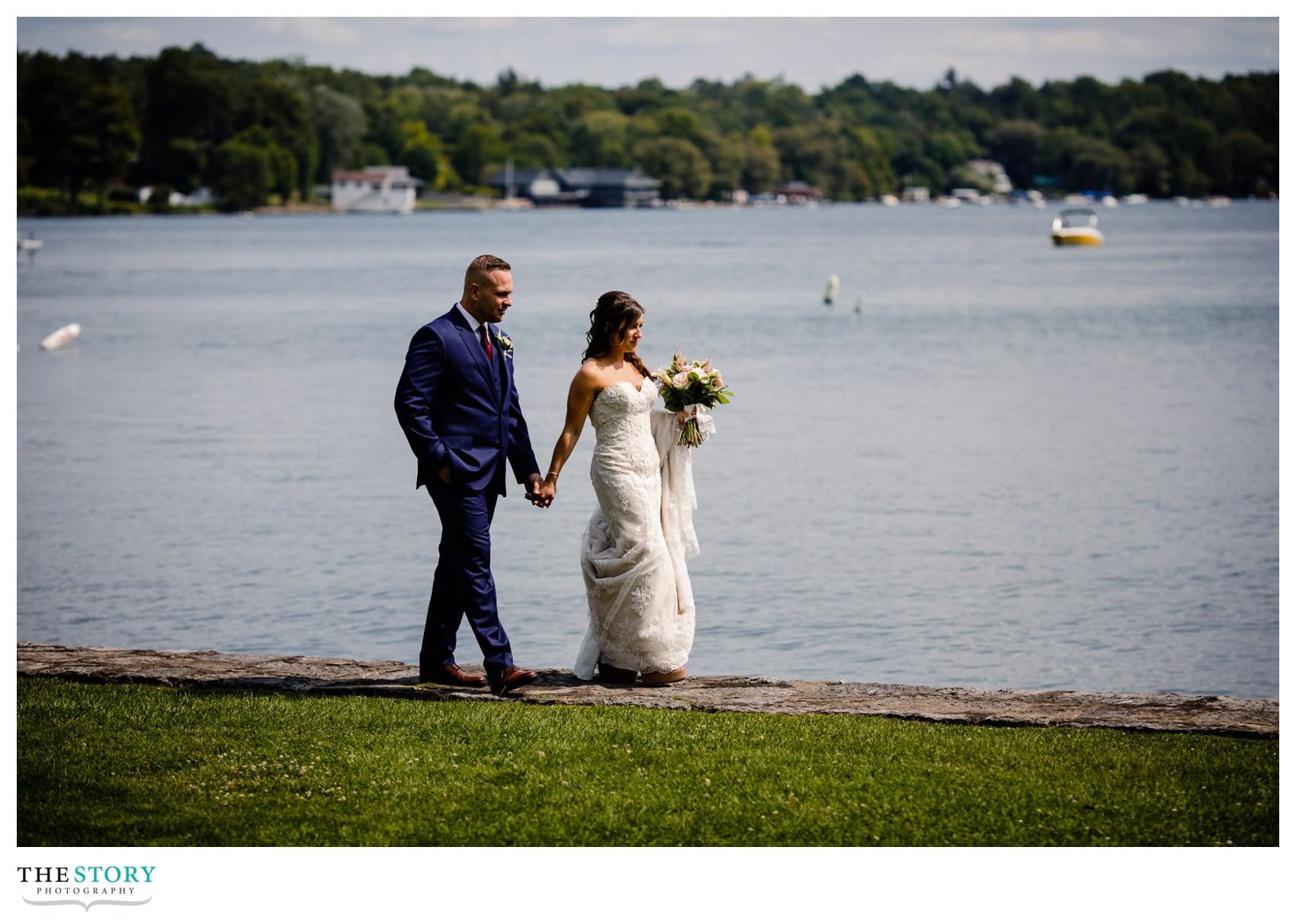 bride and groom walk along Skaneateles Lake