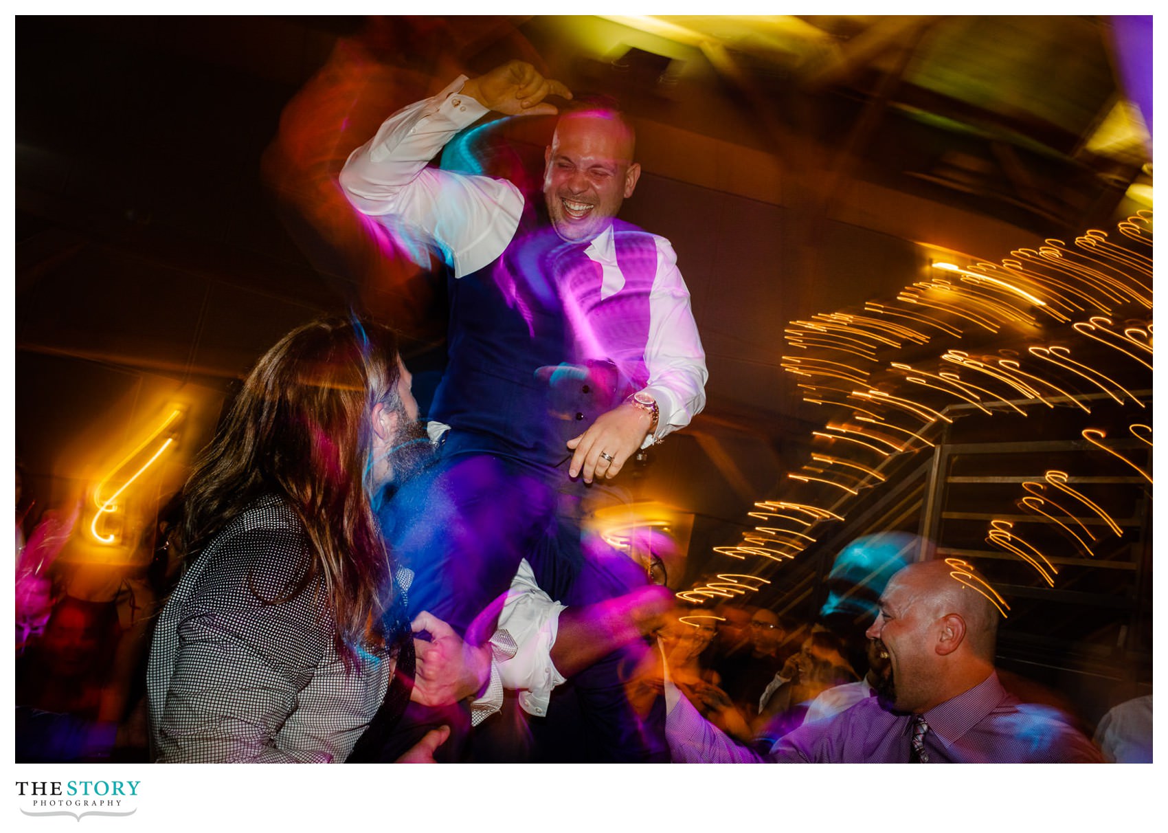 groom gets lifted up during the wedding reception at Welch Allyn