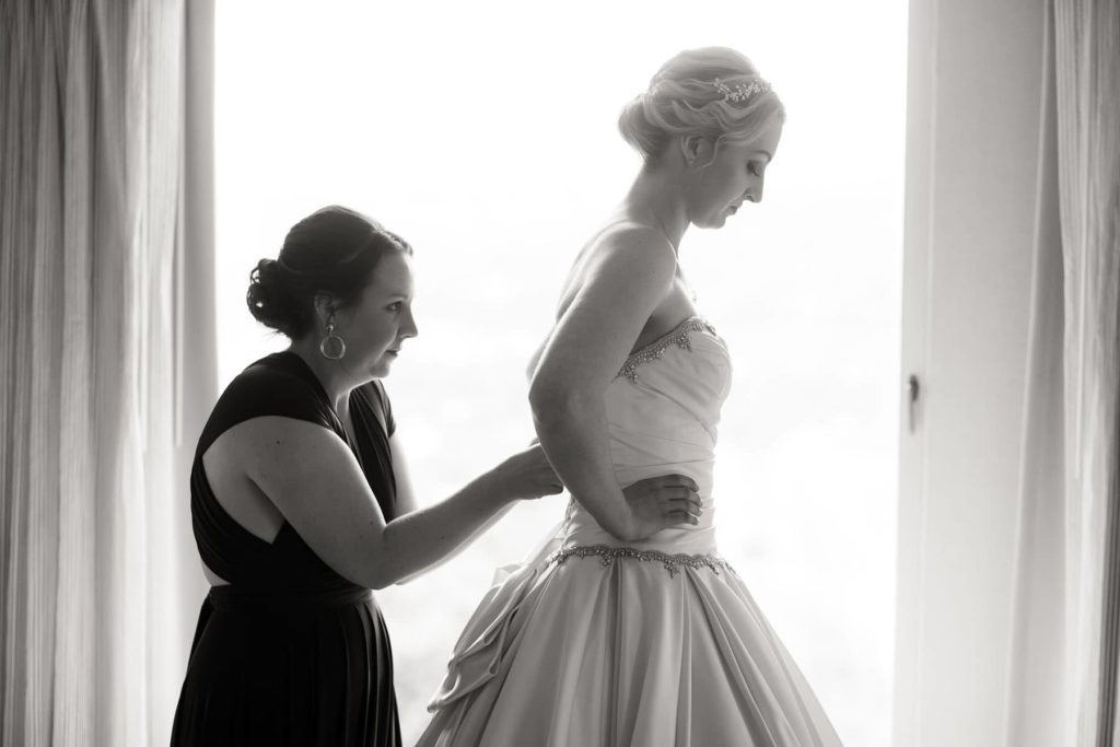 bride getting her dress buttoned up