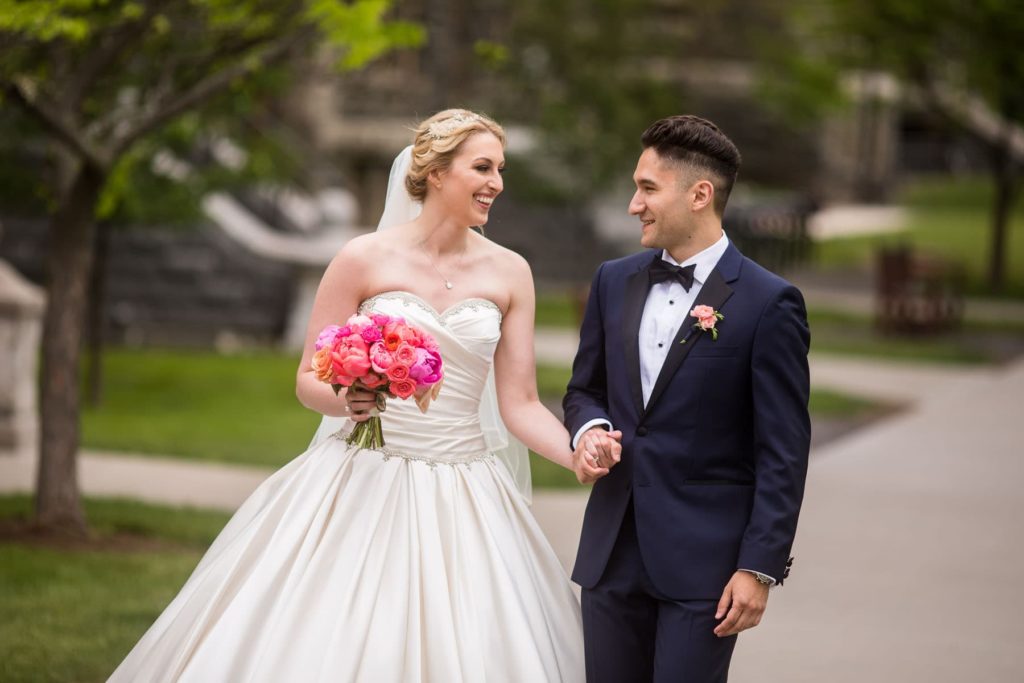 bride and groom walking on Arts Quad at Cornell