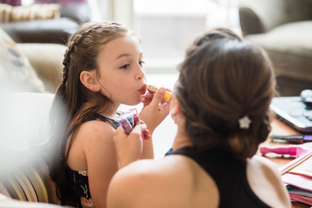 little girl getting ready for wedding day with lip stick