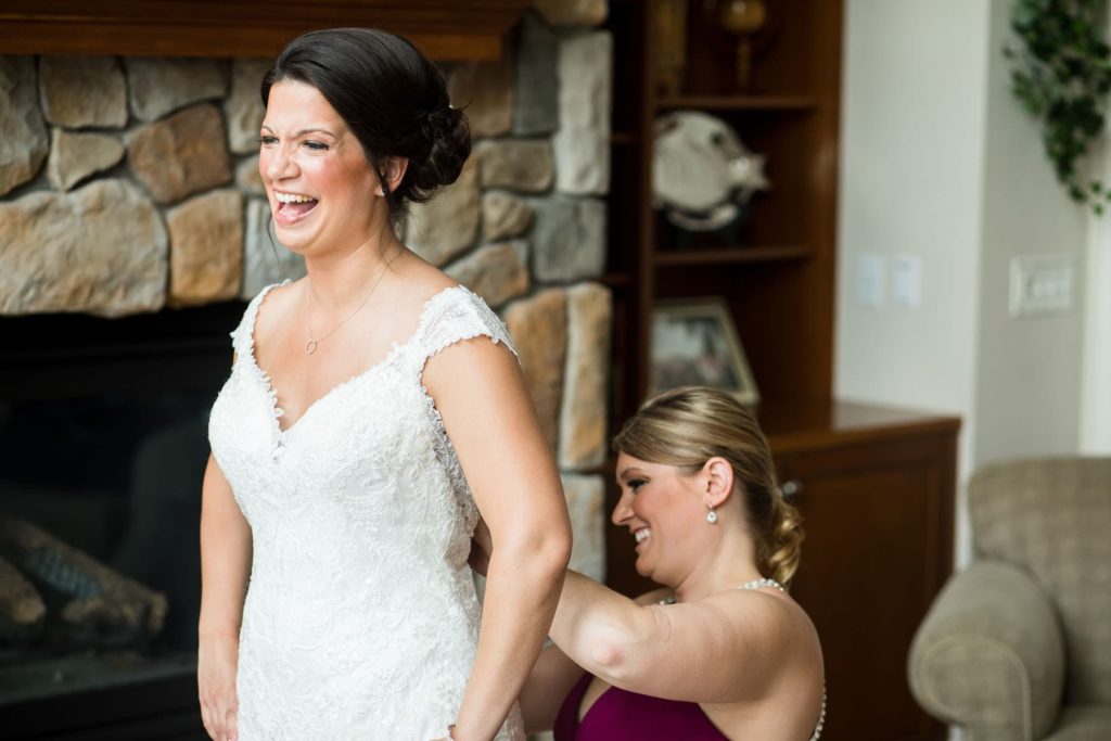 bride getting wedding dress buttoned up at Finger Lakes AirBnB