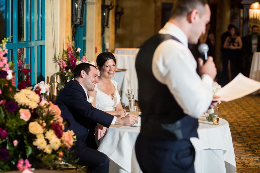 Couple enjoying a wedding speech at wedding reception